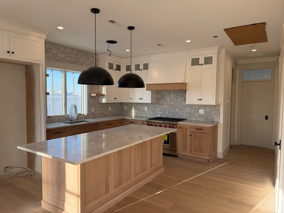 Marble-look quartz countertop and island installed in a kitchen still under renovation